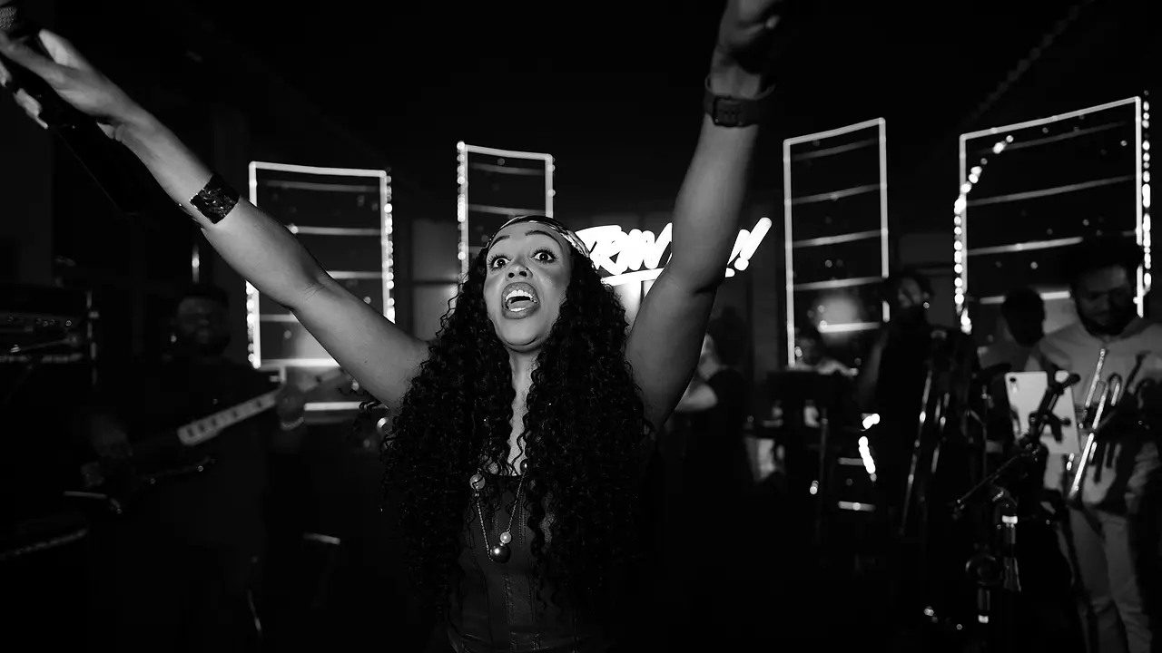 Cantora da Black SP de braços pro alto numa festa