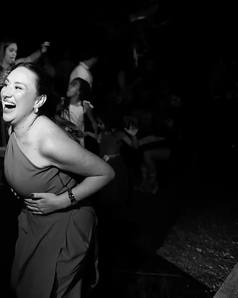 Convidada rindo e dançando na pista da festa