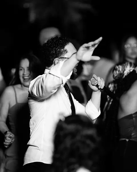 Cantor da Black SP dançando e cantando no meio dos convidados