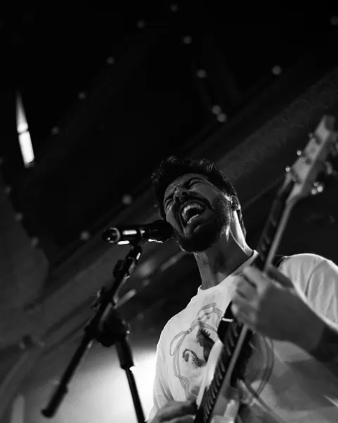 Guitarrista da Black SP cantando no microfone enquanto toca