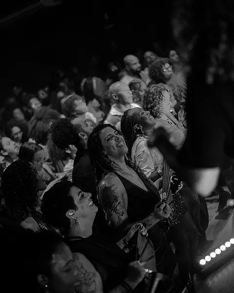A pista lotada, sorrindo e cantando colada ao palco